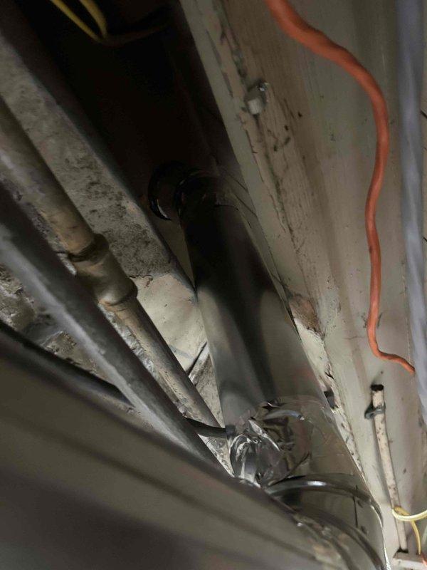 Relocated dryer vent from window opening to exterior wall ban board. Installed new venting system using 4-inch metal pipe, four 26-gauge 90-degree elbows, one 4x4x4 tee fitting, and terminated with white dryer vent cap on brick exterior. Secured all ductwork connections and capped previous opening to ensure proper airflow and code-compliant installation.