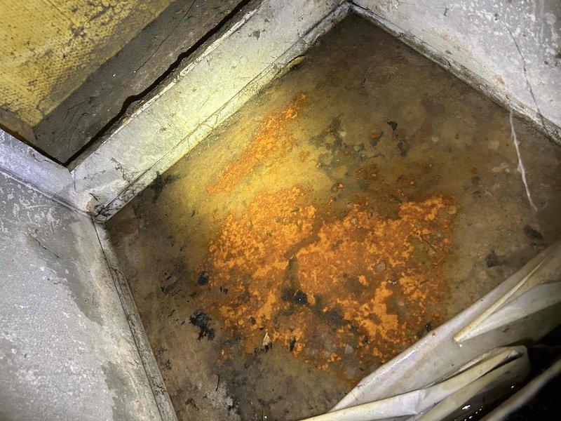Responded to service call for leaking tanked water heater located in closet. Upon inspection, discovered significant water accumulation in drain pan with extensive rust deposits and corrosion present, indicating prolonged leak condition. Water heater showed signs of tank failure with active seepage causing deterioration of surrounding containment area. Documented existing conditions with photographs showing rust-stained drain pan and corroded metal components. Assessed unit age and overall condition, noting advanced deterioration requiring replacement recommendation due to compromised tank integrity and safety concerns.