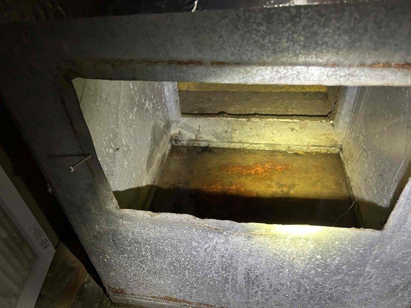 Responded to service call for leaking tanked water heater located in closet. Upon inspection, discovered significant water accumulation in drain pan with extensive rust deposits and corrosion present, indicating prolonged leak condition. Water heater showed signs of tank failure with active seepage causing deterioration of surrounding containment area. Documented existing conditions with photographs showing rust-stained drain pan and corroded metal components. Assessed unit age and overall condition, noting advanced deterioration requiring replacement recommendation due to compromised tank integrity and safety concerns.
