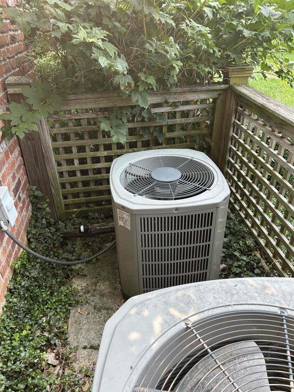 Responded to no cooling complaint on upstairs electric air conditioning system. Upon inspection, found outdoor condenser unit inoperative due to severely deteriorated electrical connection point with extensive wood rot and weather damage at the disconnect block. The compromised mounting and wiring posed both operational failure and safety concerns. Multiple colored conductors showed exposure to elements with significant decay of the wooden electrical junction box. Documented conditions of both outdoor condensing units positioned on concrete pad, noting advanced age of equipment and environmental exposure. System requires electrical repairs and replacement of damaged disconnect components to restore safe operation.