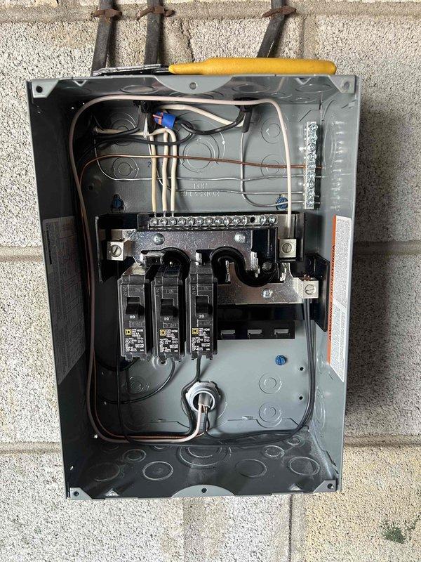 Installed electrical service to detached garage by running new circuit from main panel through exterior-mounted PVC conduit along cinder block wall. Added three new circuit breakers to existing panel and installed GFCI receptacle on interior porch wall to provide safe, code-compliant power access.