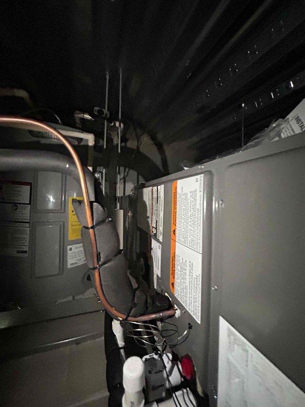 Completed full HVAC system replacement including installation of RUUD RP14AY24AJ2NA 15.2 SEER2 two-stage 2-ton heat pump outdoor unit (labeled as Unit #210), RUUD RH2TY2417STANNJ 2-ton air handler, and RUUD RXBH-1724A10J-B 10KW heat kit in attic space. Removed and properly disposed of existing equipment per code requirements. Installed overflow drain pan with water sensor and SS2 coil drain safety sensor for secondary protection. Added trap and transitioned to existing ductwork with standard-sized air filter rack. Utilized existing outdoor unit pad with snow legs, existing electrical whip kit, and existing electrical disconnect box. Installed insulated refrigerant lines with refrigerant line filter connecting outdoor unit to indoor air handler. Integrated system with existing Nest thermostat. Removed ceiling grid and tiles for equipment access and reinstalled upon completion. Obtained all applicable permits and ensured code-compliant installation. System tested, operational, and perfor