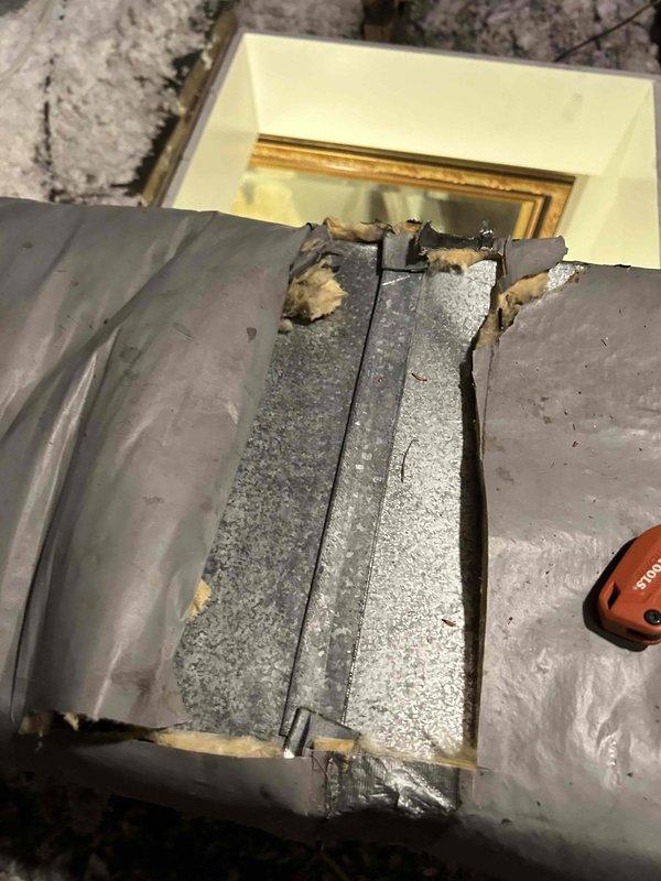 Responded to service call for thermostat unable to maintain set temperature of 72°F, with room remaining at 68°F. Upon arrival, accessed attic space to inspect HVAC system and air handler unit. Discovered significant deterioration of condensate drain pan with large crack running through center, causing structural failure and potential water drainage issues. Identified damaged and deteriorating duct insulation on primary supply duct with torn sections, frayed edges, and exposed underlying material compromising system efficiency. Documented all findings with photographs showing extent of damage to both drain pan and duct insulation. Advised that compromised drain pan poses risk of water damage and must be replaced, and damaged insulation is causing heat loss/gain affecting system's ability to maintain desired temperature. Recommended immediate replacement of cracked drain pan and re-insulation of damaged ductwork to restore proper system operation and temperature control.
