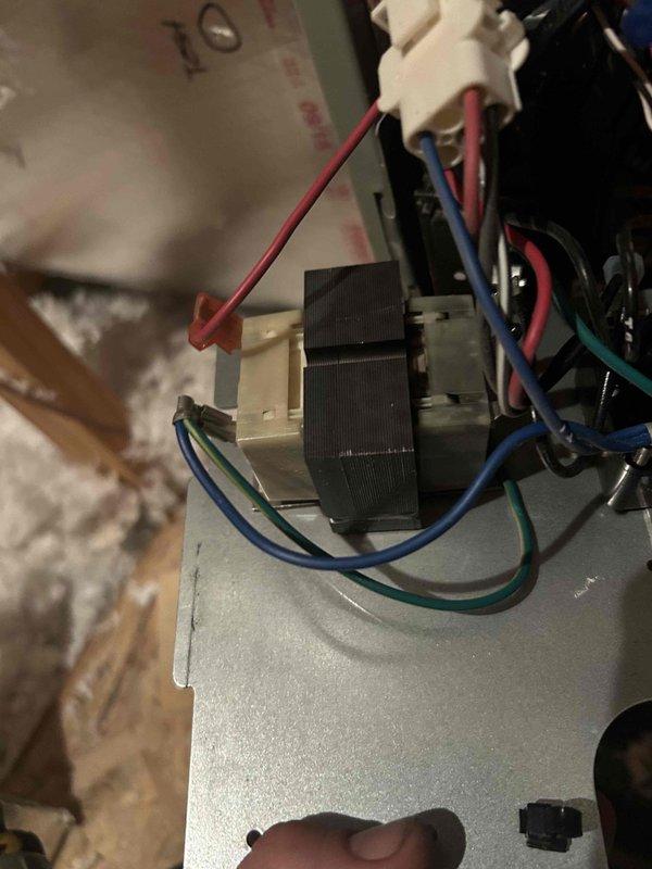 Responded to no cooling call on downstairs heat pump system. Upon inspection of the air handler unit located in attic space, discovered failed transformer with visible burn damage and melted housing. Transformer showed clear signs of thermal failure and was preventing the indoor unit from receiving power. Removed damaged transformer and replaced with new unit, reconnected all control wiring per manufacturer specifications, and restored power to system. Verified proper operation of air handler blower motor and confirmed unit now responds to thermostat calls. System operational at time of departure.