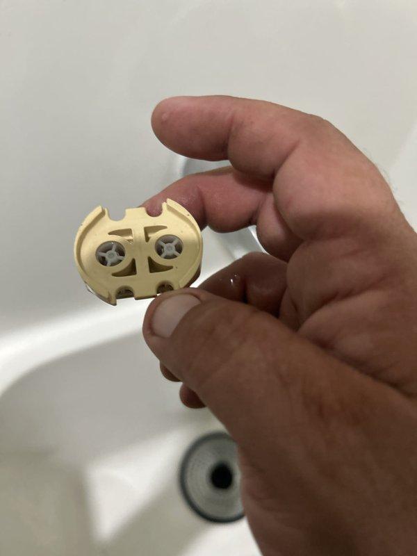 Responded to service call for leaking shower/tub valve issue. Upon inspection, identified failed diverter assembly components causing water leak. Removed and replaced defective plastic float mechanism and brass cartridge retainer from tub spout diverter valve. Photographed failed parts showing wear and deterioration of internal valve components. Tested system operation after replacement to verify proper function and confirm leak resolution.