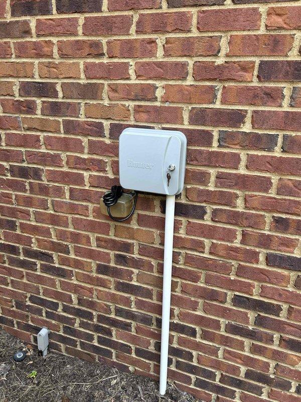 Responded to callback regarding irrigation system power loss following TXV installation. Upon arrival, inspected exterior Hunter irrigation controller and associated electrical connections mounted on brick exterior wall. Verified GFCI outdoor receptacle functionality and confirmed power restoration to irrigation system control box. Tested circuit integrity and ensured proper grounding of all exterior electrical components. 

Addressed ongoing main bedroom temperature regulation issues discussed during previous visit. Recommended installation of additional thermostat for improved zone control in main bedroom to resolve comfort concerns. System now operational with irrigation controller receiving proper power supply.