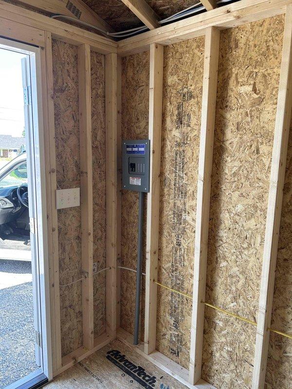 Completed full electrical installation in unfinished structure including 100-amp main panel with breakers, GFCI and duplex receptacles, single-pole switches for lighting control, recessed LED wafer cans, keyless porcelain fixture, and ceiling fan with integrated light fixture. All wiring was run through exposed framing, panel was mounted and energized, and all devices were installed and tested for proper operation per NEC standards.