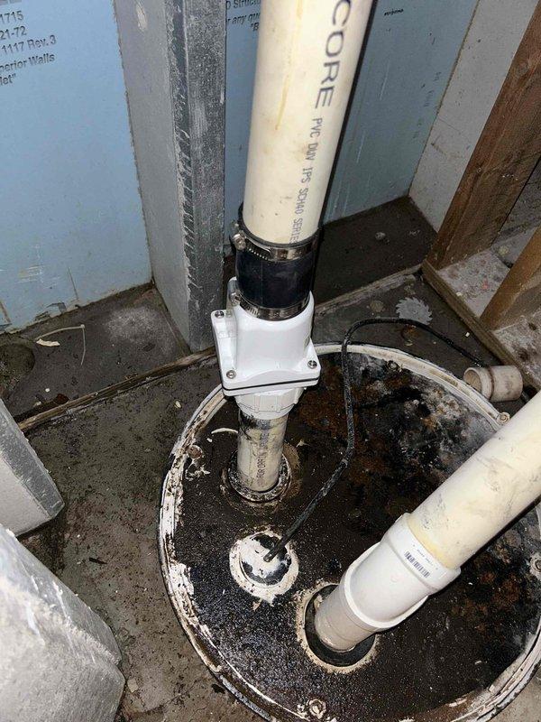 Responded to steady water leak in basement causing active damage. Upon inspection, identified compromised sump pump system with failed discharge piping and inadequate basin seal at floor penetration. Repaired PVC discharge line with proper coupling and hose clamp, addressed floor flange seal around main drain pipe to prevent groundwater intrusion, and verified sump pump operation with functional float switch mechanism. System tested and confirmed operational with no further leakage detected.