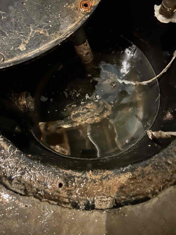 Responded to steady water leak in basement causing active damage. Upon inspection, identified compromised sump pump system with failed discharge piping and inadequate basin seal at floor penetration. Repaired PVC discharge line with proper coupling and hose clamp, addressed floor flange seal around main drain pipe to prevent groundwater intrusion, and verified sump pump operation with functional float switch mechanism. System tested and confirmed operational with no further leakage detected.