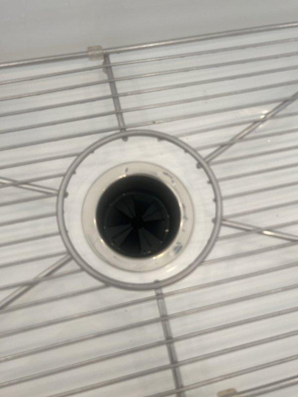 Responded to service call for garbage disposal unit not turning on. Upon inspection, discovered corroded mounting screw had failed, causing the disposal to become loose and preventing proper electrical connection. Removed deteriorated fastener, secured unit with new hardware, and verified proper operation. Unit tested successfully and returned to full functionality.