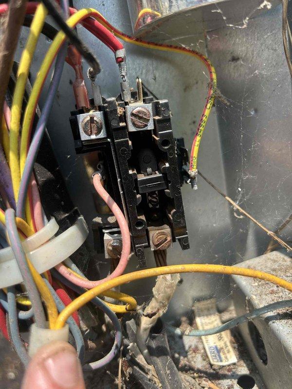 Responded to no cooling call on 15-year-old electric air conditioning system serving upstairs zone. Upon arrival, found upstairs thermostat blank with no power and system blowing warm air. Indoor unit located in upstairs bathroom, accessed via attic stairs.

Initial inspection revealed frozen evaporator coil on air handler. System was shut down to allow complete thaw before further diagnostics could be performed. Inspected outdoor condensing unit and noted electrical contactor showing signs of age with discolored terminals and weathered housing. Multiple wire connections at contactor terminals displayed normal wear consistent with system age. Outdoor refrigerant lines protected with foam insulation showed weathering and some deterioration at foundation penetration point.

Documented equipment condition with photos showing contactor assembly, wire connections, and exterior refrigerant line routing. System requires return visit after thaw cycle completes to diagnose root cause of freezin