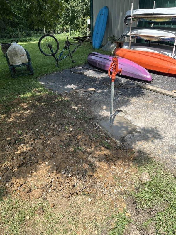 Excavated driveway area to locate existing water supply line feeding the outdoor hydrant. Cut and capped the original water line, then installed new hydrant assembly at the relocated position in the driveway. Restored excavated area with concrete replacement to match existing surface, ensuring proper grade and drainage around the new hydrant installation.