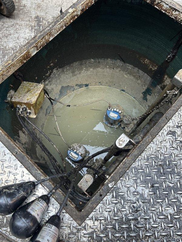 Responded to service call for dual waste pump system located in exterior fenced area behind garage structure. Conducted inspection of pump basin and control panel to assess reported bearing failure on primary unit. Confirmed one pump inoperative due to failed bearings, while secondary pump operational. Documented existing system configuration including float switches, control panel with circuit breakers, contactors, and pump control module. Photographed basin interior showing water level, pump components, float mechanisms, and diamond-plate access cover. Inspected electrical control panel revealing dual pump control system with automated switching capability. Noted system age and potential warranty coverage on equipment. Prepared comprehensive estimate for replacement of both waste pumps to ensure continued reliable operation of wastewater removal system.
