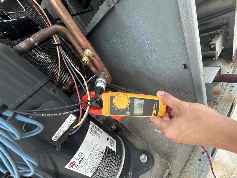 Responded to callback for HVAC system continuously tripping breaker following previous day's service visit. Upon arrival, confirmed breaker had been left in off position by customer after repeated trips. Performed electrical diagnostics on outdoor condensing unit using clamp meter and multimeter to measure amperage draw and voltage at compressor and associated components. Readings indicated compressor drawing 6.5 amps during testing. Inspected all electrical connections, wiring, capacitor, and contactor for signs of short circuit or ground fault that could cause breaker to trip. Documented findings with photos showing electrical measurements and system components for further analysis and warranty documentation purposes.
