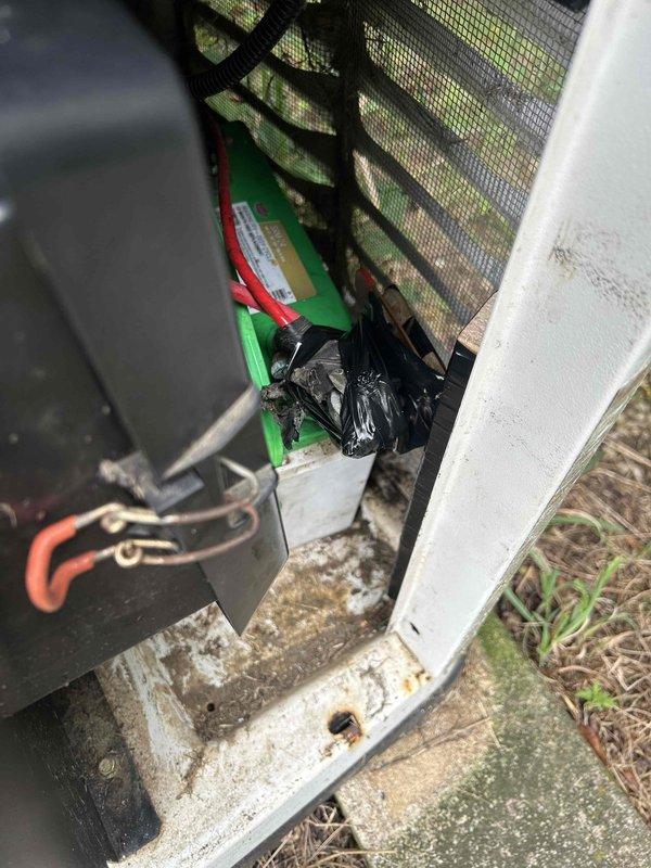 Responded to service call for Generac Evolution series generator that displayed a service message and would not start. Upon arrival, performed diagnostic inspection of the unit which showed 1985.2 run hours on the display. Assessed control panel functionality and verified all electrical connections at the generator. Inspected battery terminals and connections, noting the presence of battery cables with red and black insulation. Evaluated the control board interface showing AUTO, MANUAL, and OFF mode selections. Documented unit condition and operational status through photographs for service records.