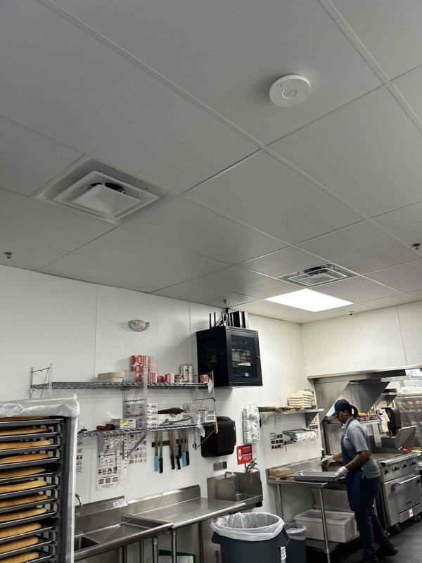 Completed HVAC Install Warranty inspection in commercial kitchen facility. Documented installation of ceiling-mounted ventilation grilles and HVAC diffusers in acoustic tile ceiling system, verified proper placement of smoke detection devices, and photographed electrical connections and control panel installations to confirm warranty compliance.