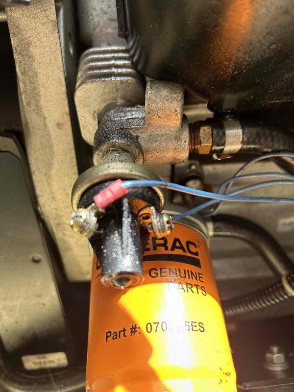 Responded to service call for Generac Guardian generator (Serial #4041830) experiencing transfer switch malfunction and oil leak. System successfully transferred to generator power during outage but failed to return to utility power, indicating automatic transfer switch issue. Inspected transfer switch panel and internal contactors, documented electrical connections and relay components. Identified active oil leak requiring attention and noted unit maintenance status evaluation needed. Photographed transfer switch assembly and generator components for diagnostic purposes.