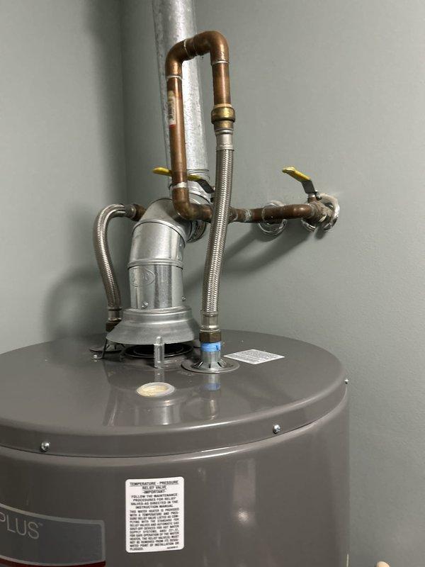 Conducted comprehensive assessment of existing 50-gallon gas-fired Rheem water heater tank installed in upstairs laundry room. Evaluated current plumbing configuration including top-mounted circulation pump, copper supply lines, flexible braided stainless steel connectors, and dual yellow-handled isolation valves. Inspected vertical galvanized vent pipe penetration through ceiling, copper branch connections, and all associated fittings for proper installation and code compliance. Documented equipment specifications, connection points, and overall system condition to provide accurate replacement estimate for tanked water heater system.