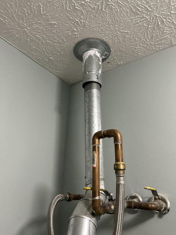 Conducted comprehensive assessment of existing 50-gallon gas-fired Rheem water heater tank installed in upstairs laundry room. Evaluated current plumbing configuration including top-mounted circulation pump, copper supply lines, flexible braided stainless steel connectors, and dual yellow-handled isolation valves. Inspected vertical galvanized vent pipe penetration through ceiling, copper branch connections, and all associated fittings for proper installation and code compliance. Documented equipment specifications, connection points, and overall system condition to provide accurate replacement estimate for tanked water heater system.