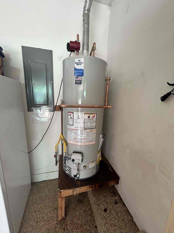 Removed and disposed of failed 50-gallon A.O. Smith gas water heater experiencing active leakage. Installed new Bradford White 50-gallon residential gas water heater on existing platform in utility closet. Connected copper supply lines to hot and cold water ports at top of unit and attached metallic vent pipe for proper exhaust ventilation. Installed recirculation pump on hot water line to provide continuous hot water circulation throughout residence. Connected gas supply line to control valve at base of unit and verified all connections for leaks using approved testing methods. Tested temperature and pressure relief valve for proper operation. Energized unit and verified ignition sequence, burner operation, and proper venting. Confirmed adequate combustion air supply and clearances meet manufacturer specifications. Allowed unit to reach operating temperature and inspected all plumbing connections under pressure for leaks. Verified proper functionality of all components prior to depart
