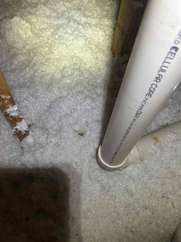 Responded to attic-mounted indoor unit with reported water leak. Upon inspection, identified minimal moisture present at drain line connections. Examined primary condensate drain system including PVC drain line and trap assembly. Verified proper pitch and drainage flow. Inspected surrounding insulation and structural components for water damage or staining. Documented conditions with photographic evidence showing drain line configuration and attic framing. System evaluated and operational at time of service.