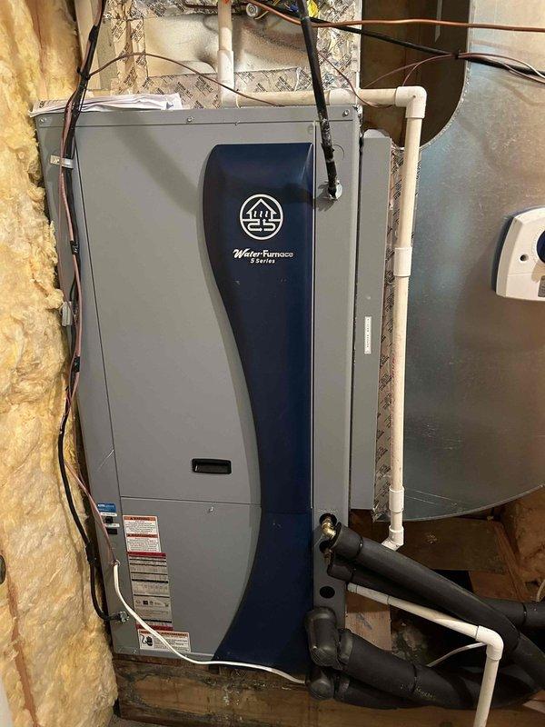 Completed residential geothermal system installation featuring a WaterFurnace 3.5-ton 5 Series packaged unit (model W5AV042BD1A12CTR2B00) configured as vertical with right return. Installed two-pump flow center (FC2-FPT), 10kW heat kit, WaterFurnace digital thermostat (TPCC32U03WWFI), hot water de-superheater, UV light system, and condensate pump. 

Return visit performed to finalize installation work. Replaced 16x20x4" air filter on upstairs air handler. Modified supply transition by replacing front face and repositioned humidifier mounting as high as possible to maintain clearance from heat strips. Re-worked humidifier drain line for proper drainage. Installed new saddle tap for humidifier water supply line. Completed electrical connections for humidifier and humidifier control wiring. 

Piped in de-superheater for domestic hot water heating integration. Insulated all geothermal loop lines to prevent condensation and maintain system efficiency. Installed return drop ductwork. System 