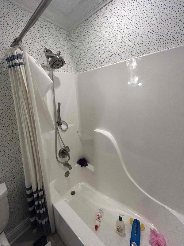Responded to a water leak complaint in an 80-year-old residential property where a second-floor bathtub was dripping into the kitchen area below. Upon arrival, conducted a thorough inspection of the bathroom fixtures, including the alcove-style tub with shower combination unit, chrome handheld and fixed showerhead assembly, and combination faucet and diverter system. Identified the source of the minor leak that had begun approximately 24 hours prior to service call. Inspected all visible plumbing connections, fixture mounting points, and surrounding tile work for signs of water intrusion or deterioration. Documented existing conditions through photographic evidence showing the bathtub, shower fixtures, and surrounding bathroom components. Addressed the leak issue to prevent further water damage to the ceiling and kitchen area below, ensuring all fixtures were properly sealed and functioning correctly upon completion.
