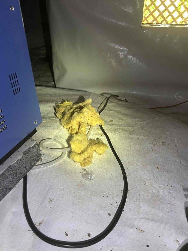 Responded to no cooling complaint on system less than 10 years old. Found evaporator coil frozen solid with ice extending all the way to the outdoor unit. Pulled disconnect to allow complete thaw of coil. Discovered significant return air deficiency during inspection, with inadequate return airflow contributing to freezing condition. Removed displaced fiberglass insulation material found inside air handler cabinet. System requires proper return air sizing to prevent future freeze-ups and ensure adequate airflow across evaporator coil.