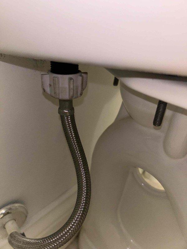 Responded to complaint of whistling shut-off valve behind toilet. Inspected wall-mounted chrome shut-off valve and flexible braided stainless steel supply line connecting to toilet tank. Valve was producing audible whistling noise but showed no visible water leakage at time of inspection. Examined supply line connections at both wall valve and tank inlet, noting standard installation with proper coupling. Multiple toilets present in home but issue isolated to single fixture.
