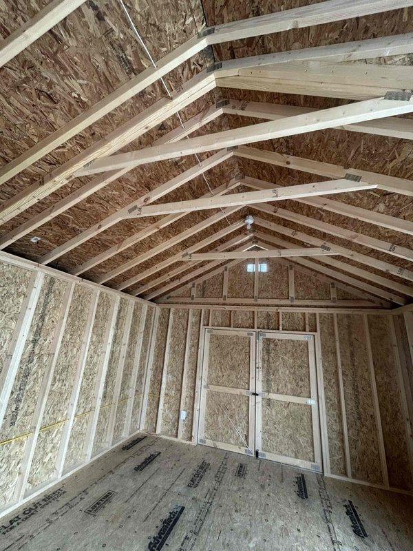 Completed electrical installation in new construction outbuilding, including installation of 100-amp main electrical panel with two circuit breakers, one GFCI receptacle, two duplex receptacles, one single-pole switch, and two keyless light fixtures. All wiring and devices installed per code requirements in the unfinished structure with exposed OSB sheathing and structural framing.