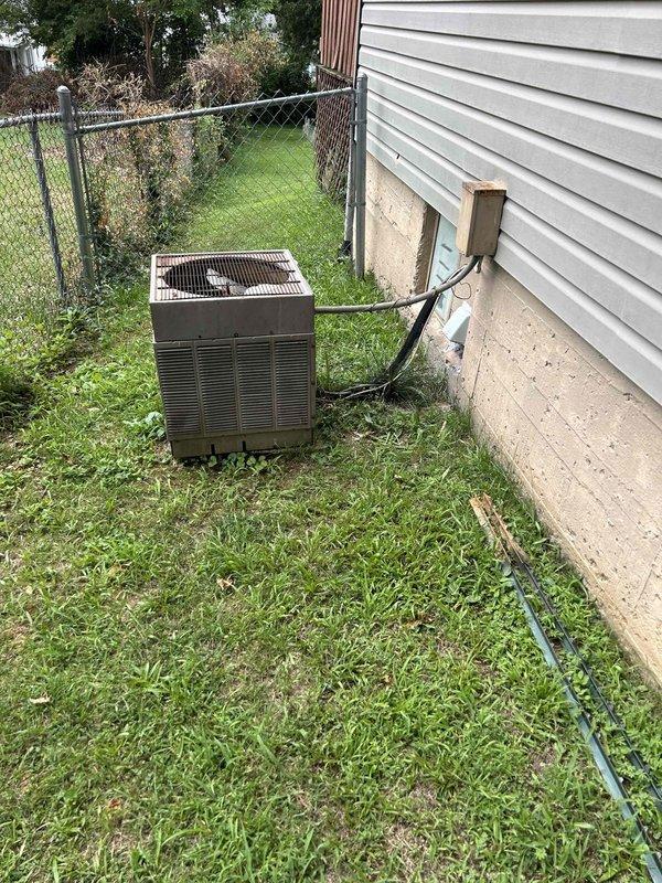 Responded to no-cool call on 40+ year old residential air conditioning system with outdoor condenser unit not running and indoor unit blowing warm air. Performed diagnostic inspection of outdoor condenser unit and indoor air handler located in basement. Assessed system condition, checked electrical connections at disconnect box, and evaluated thermostat operation showing 90-degree indoor temperature reading on Honeywell Home unit.
