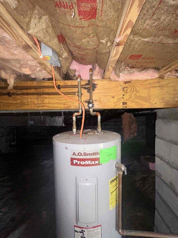 Responded to water intrusion in crawl space following previous plumbing work by another contractor. Inspected A.O. Smith ProMax water heater and surrounding plumbing connections, identifying source of moisture accumulation beneath floor joists. Collected standing water and documented conditions of copper piping, fittings, and valve connections at water heater installation point.