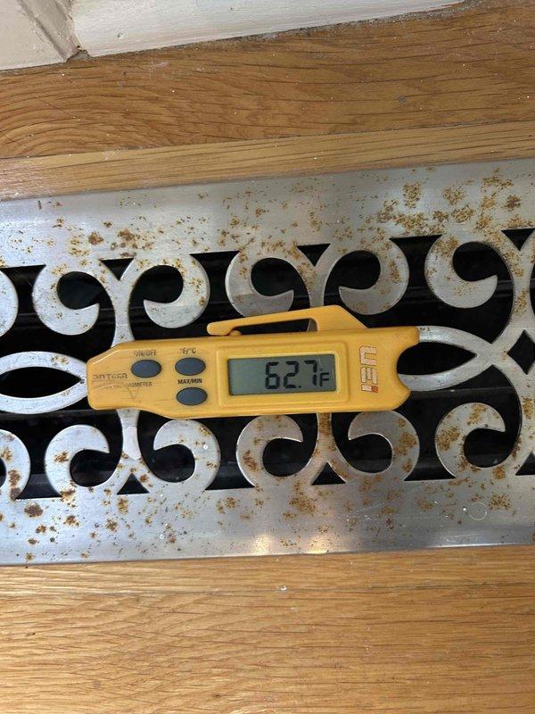 Responded to no cooling complaint on 10+ year old electric air conditioning system with thermostat set to 71°F but indoor temperature reading 75°F. Performed diagnostic evaluation of system performance and measured supply air temperatures at floor register. Digital thermometer readings indicated supply air temperatures of 62.7°F and 61.3°F, which are insufficient for proper cooling and suggest inadequate system capacity or refrigerant charge issues. Documented findings with photographic evidence of register temperatures for further evaluation. Recommended contacting office to discuss diagnostic findings and repair options to restore adequate cooling performance to residence.