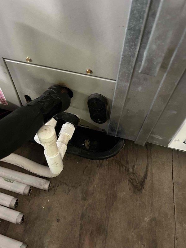 Responded to callback for persistent water leak from upstairs air handler causing significant water accumulation in basement below. Upon inspection, found improperly installed condensate drain system with inadequate P-trap configuration allowing water to bypass drainage path and leak onto floor. Disassembled existing PVC drain assembly, removed defective components, and reinstalled proper condensate drain piping with correctly configured P-trap to ensure proper drainage and prevent future leaks. Verified system operation and confirmed no active leaking from unit or drain connections.