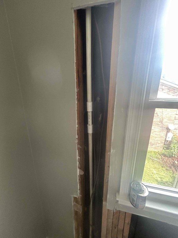 Responded to customer report of condensate line leak causing interior water damage. Upon arrival, found drywall had been removed by homeowner, exposing vertical PVC condensate drain pipe with visible crack and deterioration. Inspected damaged pipe section and confirmed active leak from fractured condensate line. Documented condition with photographs showing cracked PVC pipe with discoloration and linear defect. Removed damaged section of condensate drain pipe and assessed surrounding plumbing connections. Discussed repair options with customer including full pipe replacement versus sectional repair to restore proper drainage function and prevent further water damage to interior walls.