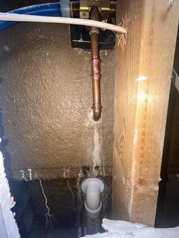 Responded to emergency water leak originating from second-story bathroom with damage visible in closet below. Upon investigation, accessed wall cavity and inspected plumbing system serving tub/shower area. Located source of water intrusion at copper supply line connection with compromised fitting. Repaired leaking connection using brass compression fittings and secured copper piping with proper mounting brackets. Applied spray foam insulation around plumbing penetrations to seal cavity and prevent future moisture migration. Documented water-damaged drywall in lower closet showing bowing and saturation requiring replacement by property owner or contractor.