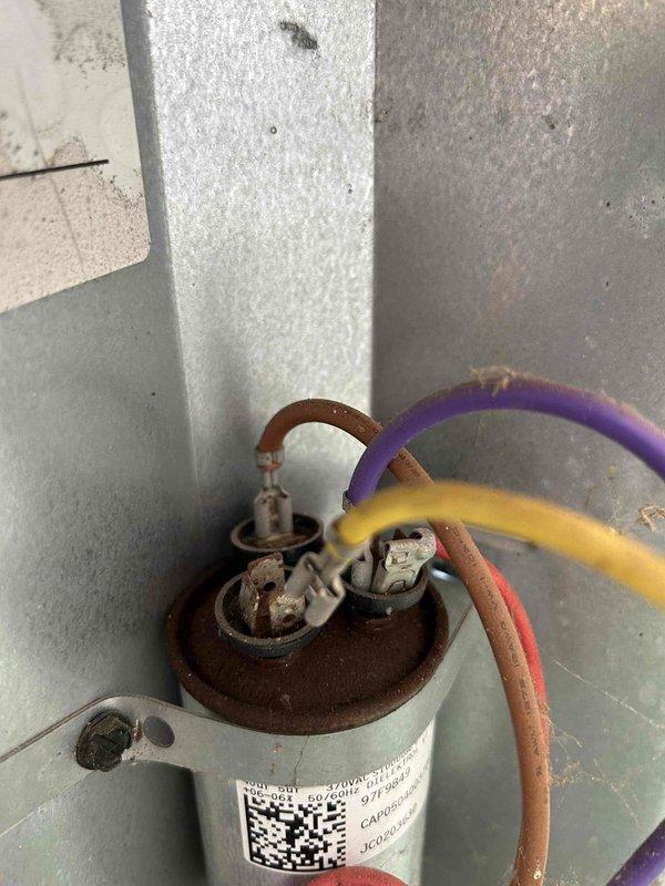Responded to no cooling complaint on 10-15 year old gas/electric split system experiencing warm air discharge since previous evening. Upon inspection, discovered failed dual run capacitor with severe terminal corrosion and oxidation on top cap, preventing compressor and condenser fan motor operation. Replaced defective capacitor with manufacturer-specified replacement, verified proper microfarad ratings, and tested system startup sequence. Confirmed compressor engagement, proper condenser fan operation, and return to normal cooling cycle with appropriate temperature split across evaporator coil.