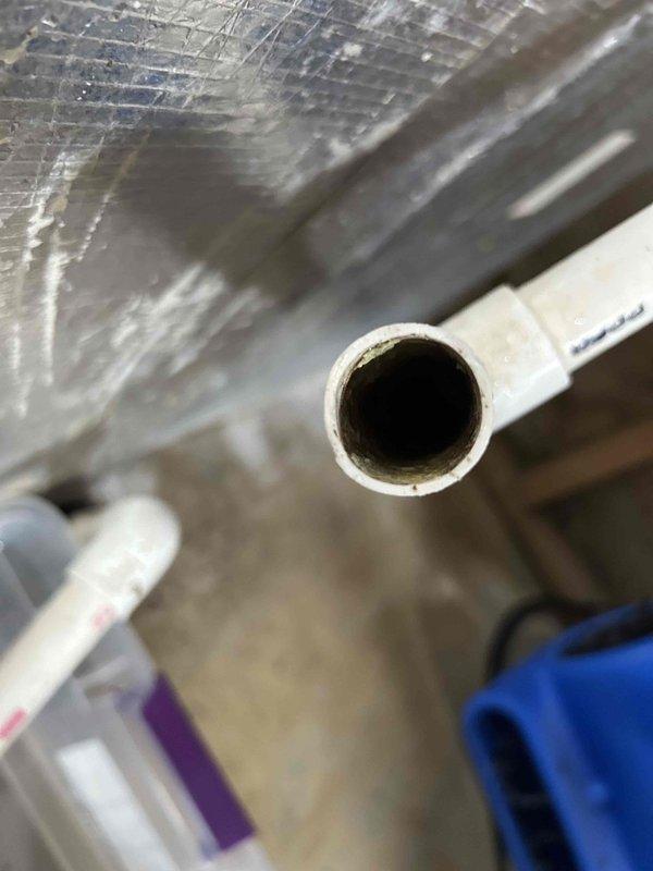 Responded to water leak at basement indoor unit with standing water inside equipment causing wall damage. Found condensate drain line completely clogged, preventing proper drainage and resulting in water accumulation within the system. Cleared blockage from condensate line and verified proper drainage flow to prevent further water damage to equipment and surrounding structure.