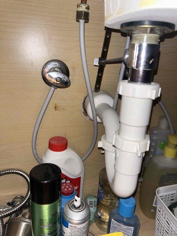 Completed comprehensive 65-point plumbing inspection of residential property. Inspected bathroom vanity sink and faucet assembly, verifying proper water flow and drainage operation. Examined under-sink plumbing components including chrome pop-up drain assembly, white PVC P-trap configuration with coupling nuts, and flexible supply lines for leaks or deterioration. Tested faucet functionality with single-handle chrome fixture, confirming adequate water pressure and temperature control operation. All visible plumbing fixtures and connections found to be in serviceable condition with no active leaks detected at time of inspection.
