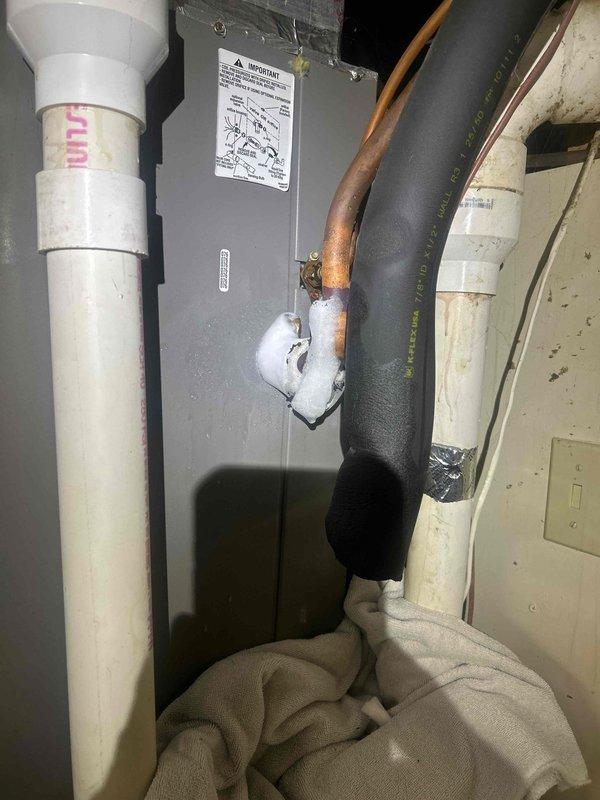 Responded to water leak complaint on 9-year-old air conditioning system that was still providing adequate cooling. Upon inspection, identified active condensate drainage issue at indoor air handler unit. Cleared primary condensate drain line obstruction and verified proper drainage flow through PVC condensate piping system. Placed absorbent material to monitor for additional leakage and confirmed system operation with no further water discharge detected at unit location.