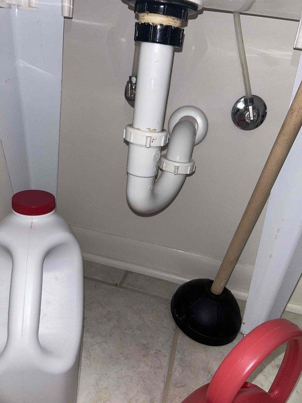 # Plumbing Inspection Summary

Completed routine plumbing preventative service agreement inspection of residential property. Performed comprehensive visual assessment of accessible plumbing systems and fixtures per recurring maintenance plan protocol.

## Water Heater Inspection

Inspected Rheem Professional water heater unit located in basement utility area. Verified proper installation positioning and clearances. Examined all visible connections including copper supply lines, PVC venting system, and pressure relief valve assembly. Noted red-handled temperature and pressure relief valve present and properly installed. Checked for signs of corrosion, leakage, or deterioration on tank exterior and all pipe connections. Observed insulation wrapping on hot water distribution line. Unit appeared to be functioning within normal parameters with no active leaks or safety concerns identified at time of inspection.

## Under-Sink Plumbing Assessment

Inspected bathroom sink drain assembly and w