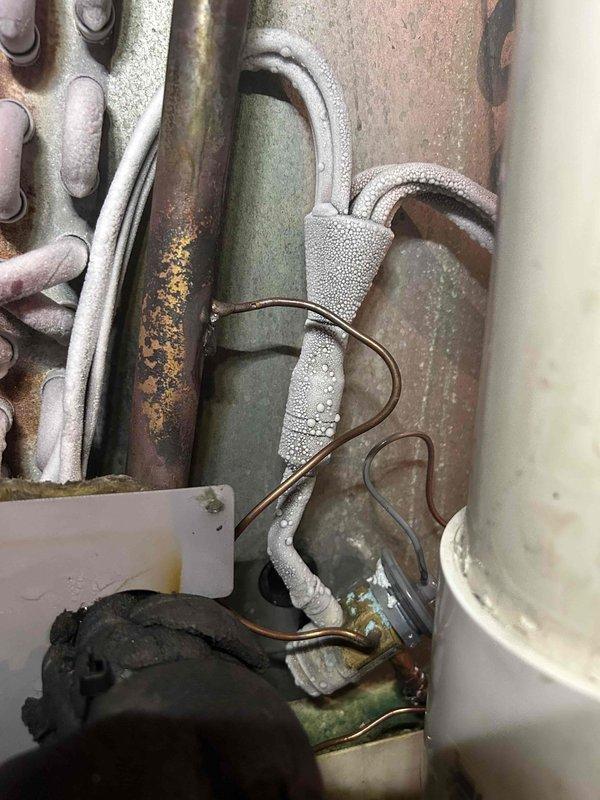 Responded to no cooling complaint on 15-year-old HVAC system experiencing repeat failure after recent repair. Upon inspection, discovered extensive frost buildup on refrigerant lines and evaporator coil indicating restricted airflow or low refrigerant charge. Found significant corrosion and rust on copper piping and electrical panel components consistent with age and environmental exposure. Diagnosed underlying issue causing system failure, performed necessary repairs to restore cooling operation, and verified proper system function before departure.