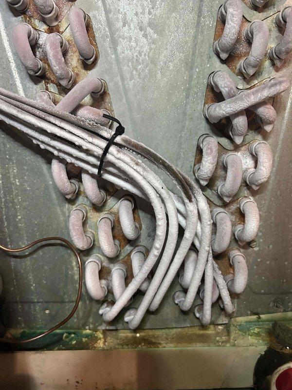 Responded to no cooling complaint on 15-year-old HVAC system experiencing repeat failure after recent repair. Upon inspection, discovered extensive frost buildup on refrigerant lines and evaporator coil indicating restricted airflow or low refrigerant charge. Found significant corrosion and rust on copper piping and electrical panel components consistent with age and environmental exposure. Diagnosed underlying issue causing system failure, performed necessary repairs to restore cooling operation, and verified proper system function before departure.