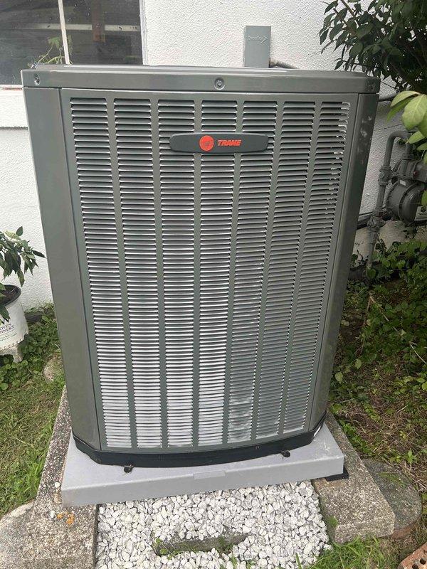 Completed full residential HVAC system replacement including installation of Trane 100K BTU two-stage 97% efficiency gas furnace (model S9V2C100U5VSBB), Trane 5-ton 14.3 SEER2 air conditioning unit (model 5TTR4060A1000A), matching evaporator coil (model 5TXCCOO7AS3HCA), and digital thermostat. Removed existing equipment and disposed of properly, then installed bottom base box to ensure proper airflow for the AC unit. Removed old humidifier and patched penetration hole in ductwork. Installed outdoor condenser unit on new concrete pad with gravel packed between and around pavers to eliminate hollow spots and ensure stable, level support. Connected refrigerant lines with proper insulation, installed electrical whip kit and disconnect box at outdoor unit, and ran electrical conduit along exterior wall. Installed flexible gas line connector with gas shut-off switch, connected to flue piping with proper transitions, and added flame roll-out protection. Installed electrical shut-off switch, s