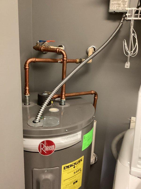 Responded to service call for Rheem Classic 50-gallon electric water heater (model PROE50 M2 RH95) with inadequate hot water duration. Upon arrival, performed diagnostic evaluation of unit installed in 2023. Inspected electrical connections, thermostat settings, and heating element functionality. Tested temperature and pressure relief valve operation and verified proper copper piping connections with ball valve shut-off. Assessed upper and lower heating elements for continuity and proper resistance values. Checked thermostat calibration and temperature settings on both upper and lower units. Evaluated sediment accumulation and tank condition. Confirmed unit remains under manufacturer's 10-year tank warranty. Documented findings with photographic evidence showing complete installation including copper piping configuration, electrical conduit, and overall system condition.