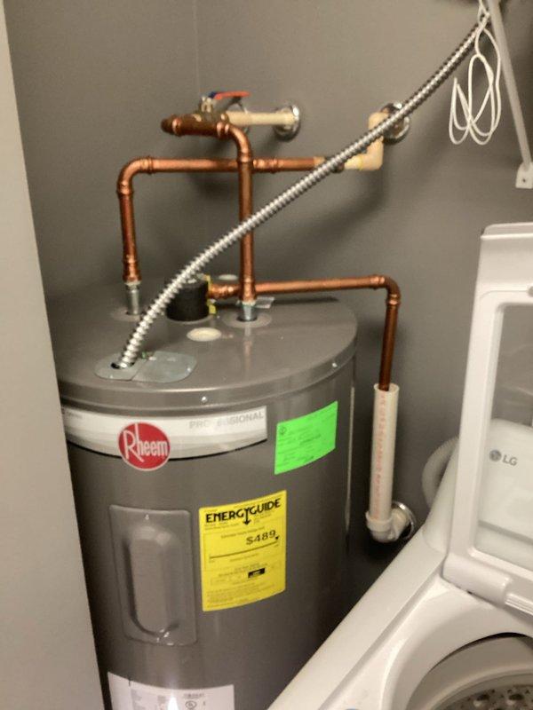 Responded to service call for Rheem Classic 50-gallon electric water heater (model PROE50 M2 RH95) with inadequate hot water duration. Upon arrival, performed diagnostic evaluation of unit installed in 2023. Inspected electrical connections, thermostat settings, and heating element functionality. Tested temperature and pressure relief valve operation and verified proper copper piping connections with ball valve shut-off. Assessed upper and lower heating elements for continuity and proper resistance values. Checked thermostat calibration and temperature settings on both upper and lower units. Evaluated sediment accumulation and tank condition. Confirmed unit remains under manufacturer's 10-year tank warranty. Documented findings with photographic evidence showing complete installation including copper piping configuration, electrical conduit, and overall system condition.