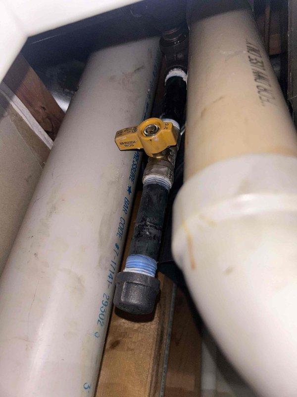 Completed full replacement of residential tanked water heater in utility closet installation. Removed existing unit and installed new white cylindrical water heater with proper clearances and code-compliant connections. Connected hot and cold water supply lines using copper piping with red-handled and blue-handled shut-off valves at unit top for isolation capability. Verified gas supply connection with yellow ball valve shut-off mechanism and black iron gas pipe with properly sealed threaded connections. Ensured all plumbing connections were secure and leak-free, with water heater properly positioned within confined closet space. Installation includes standard electrical connection via wall outlet and meets manufacturer specifications for residential water heating system operation.