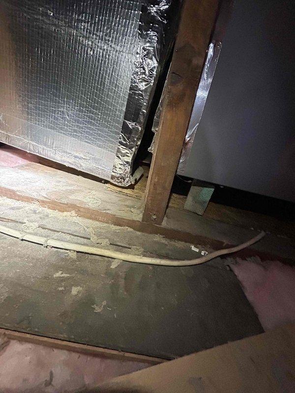# HVAC Service Report - No Cool Condition

Responded to service call for one-year-old air conditioning system with insufficient cooling capacity. Unit was providing some cooling but failing to maintain desired temperature setpoints throughout the property.

Upon arrival, performed visual inspection of outdoor condensing unit and indoor air handler components. Proceeded to attic space to examine air distribution system and indoor equipment. During inspection, discovered compromised ductwork insulation at critical connection points near the air handler unit. Black exterior insulation jacket was torn and separated from duct surfaces, with underlying reflective vapor barrier material exposed, crumpled, and improperly sealed.

The deteriorated insulation condition was causing significant thermal loss at the supply plenum connection, allowing conditioned air to lose temperature before reaching living spaces. This explained the reduced cooling performance despite the system being relatively n