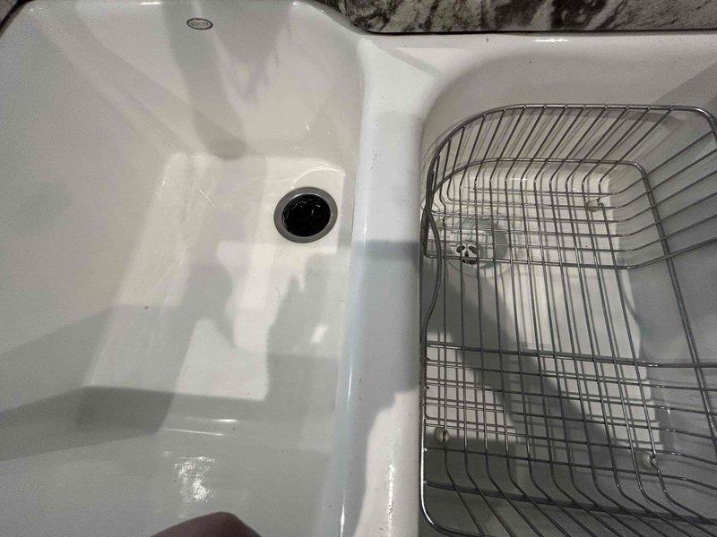Responded to service call for kitchen sink with garbage disposal backing up. Performed complimentary whole home plumbing inspection as requested. Inspected double-basin kitchen sink with garbage disposal unit installed in left basin. Examined disposal operation, drain assembly, and P-trap configuration. Assessed water supply connections and drain lines behind adjacent appliances to verify proper venting and drainage flow. System evaluated for blockages, improper installation, or mechanical failure of disposal unit.