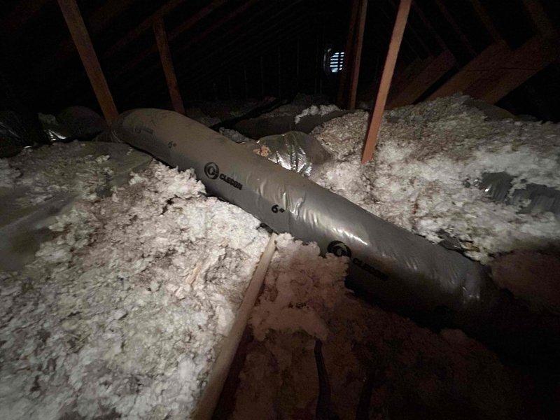 # HVAC Service Completed

Responded to no-cooling complaint on 6-year-old Bryant heat pump system located in attic. Unit experiencing complete shutdown with issue persisting through two prior service visits. 

Upon arrival, performed comprehensive system diagnostics. Accessed attic-mounted air handler and inspected all major components. Evaluated ductwork system, noting flexible duct runs throughout attic insulation. Examined condensate drain line and discovered complete blockage causing primary drain pan to fill, triggering float switch safety shutdown. 

Removed and disassembled condensate drain line section, revealing significant algae and debris accumulation restricting water flow. Cleared blockage from drain line using appropriate tools and cleaning methods. Flushed entire condensate system to ensure proper drainage. Reinstalled drain components with proper insulation. Verified float switch operation and reset safety controls.

Tested system operation through complete cooling cycl